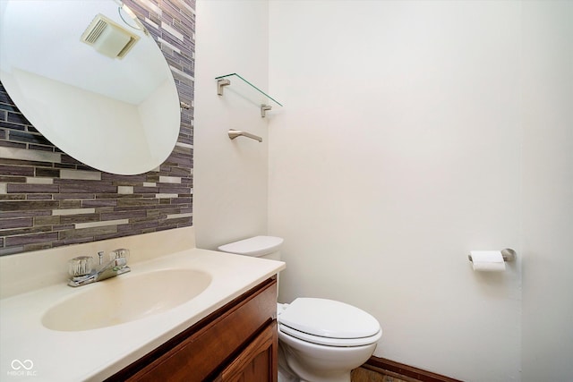 403 Hawthorn Dr, Crawfordsville, IN 47933 - half bathroom featuring vanity, toilet, and tasteful backsplash