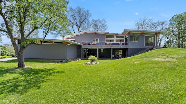 back of house with a sunroom, a lawn, and a deck