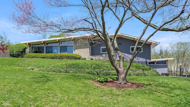 view of property exterior with a yard and stone siding
