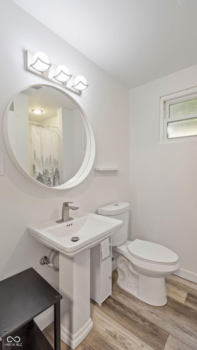 bathroom featuring toilet and wood finished floors