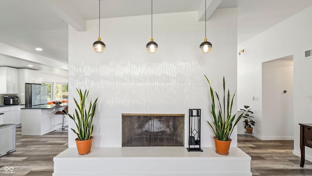 living area featuring a fireplace with raised hearth, recessed lighting, baseboards, wood finished floors, and visible vents