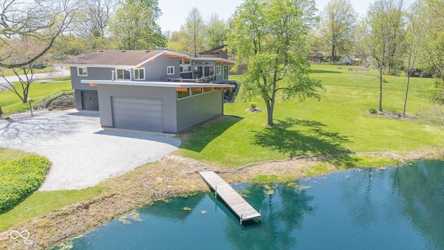 exterior space featuring a water view, an attached garage, driveway, and a front yard