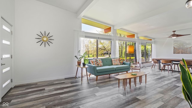 sunroom with a deck, baseboards, beam ceiling, and wood finished floors