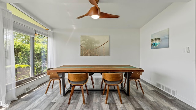 dining room featuring visible vents, a healthy amount of sunlight, and wood finished floors
