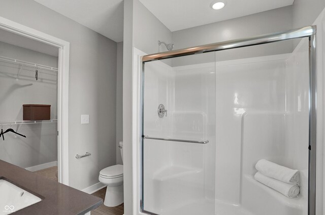 7645 Marin Pkwy, Cumberland, IN 46229 - full bathroom featuring a sink, a walk in closet, toilet, and a shower stall