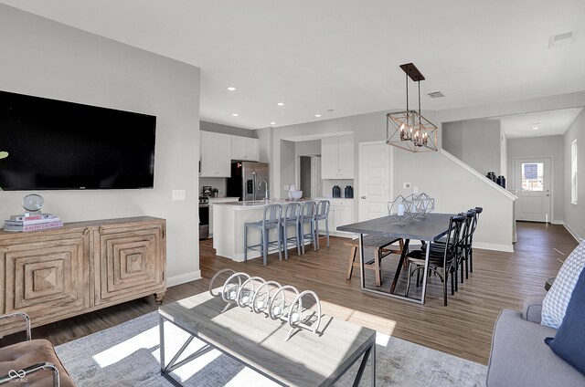 7645 Marin Pkwy, Cumberland, IN 46229 - living room featuring baseboards, visible vents, wood finished floors, and a chandelier