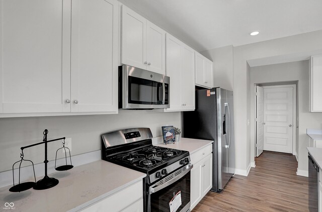 7645 Marin Pkwy, Cumberland, IN 46229 - kitchen featuring baseboards, light wood-style flooring, stainless steel appliances, and white cabinetry