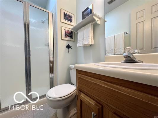 full bathroom with vanity, a stall shower, visible vents, and toilet