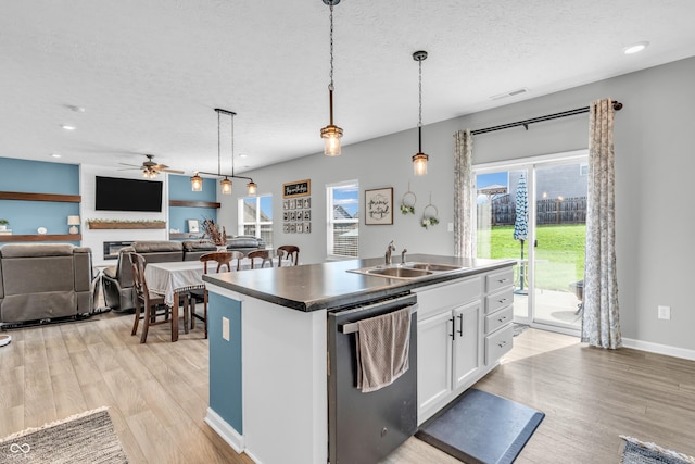kitchen with stainless steel dishwasher, visible vents, a sink, and light wood-style flooring