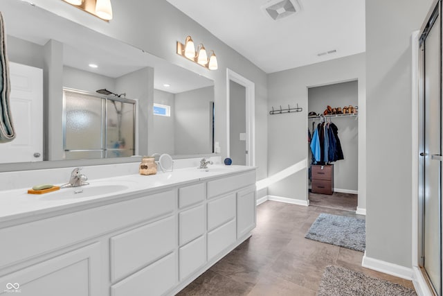 full bathroom with double vanity, a shower stall, and a sink