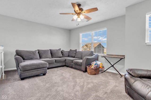 carpeted living room with baseboards, a ceiling fan, and visible vents