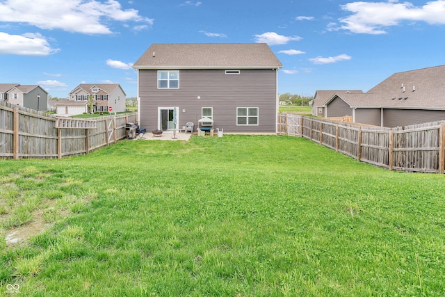 back of house with a fenced backyard, a patio area, and a yard
