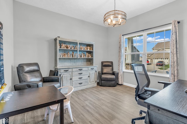 office area featuring light wood-style floors, baseboards, and a chandelier
