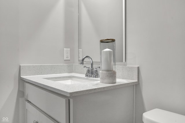 half bath featuring vanity and toilet