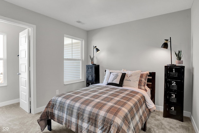 bedroom featuring visible vents, baseboards, and light colored carpet
