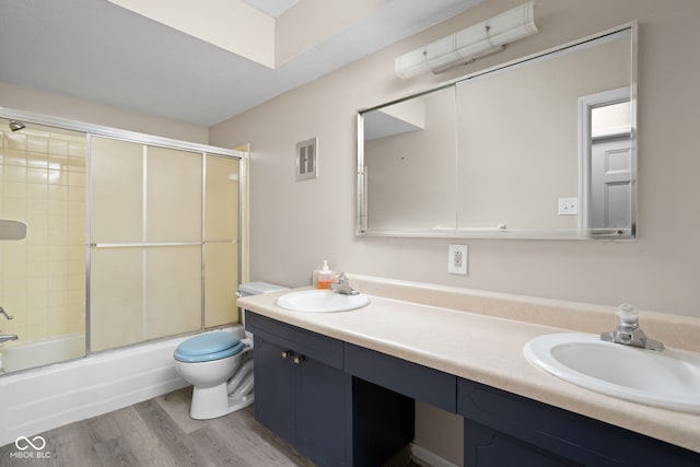 full bathroom featuring visible vents, wood finished floors, vanity, toilet, and shower / bath combination with glass door