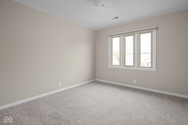 empty room featuring baseboards, carpet flooring, and visible vents