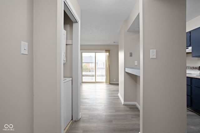 hall featuring light wood-style floors and baseboards