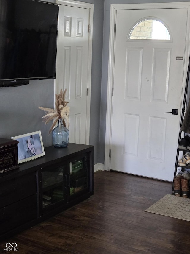 foyer featuring baseboards and dark wood-style flooring