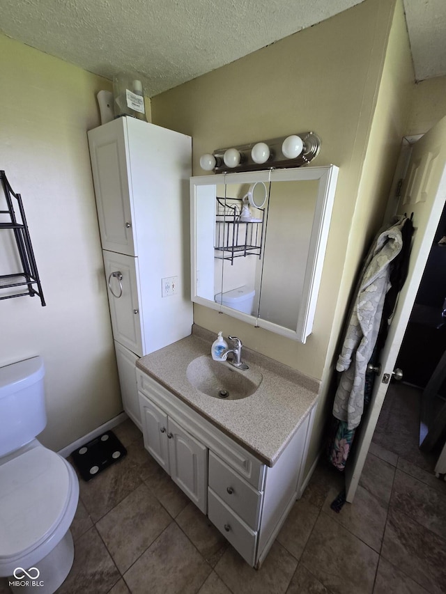 bathroom featuring toilet, tile patterned flooring, and vanity