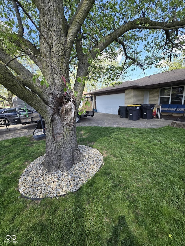 view of yard with an attached garage and a patio area