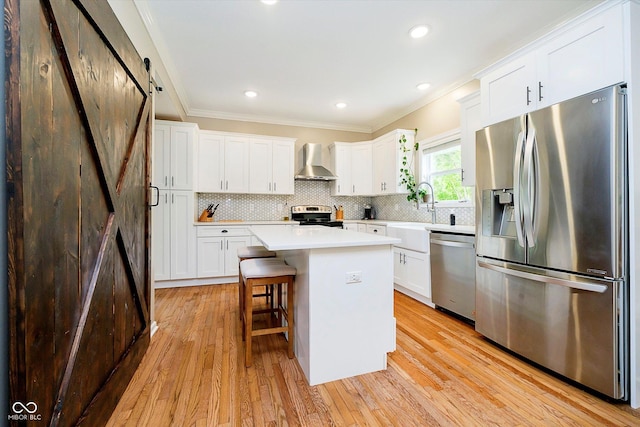 11141 Saybrook Ct, Fishers, IN 46037 - kitchen with appliances with stainless steel finishes, wall chimney exhaust hood, a sink, crown molding, and light countertops