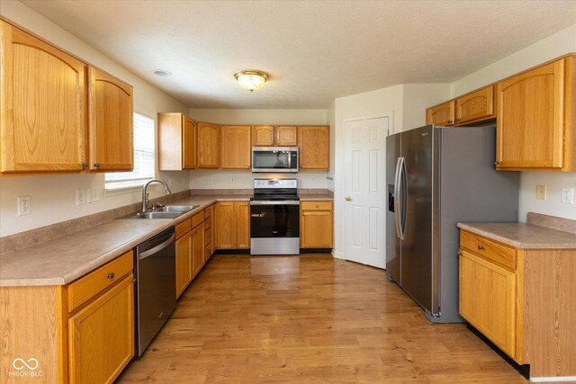 6516 Amherst Way, Zionsville, IN 46077 - kitchen featuring appliances with stainless steel finishes, light wood-style flooring, and light countertops