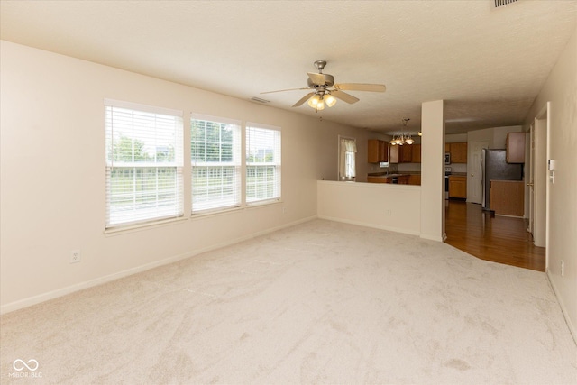 6516 Amherst Way, Zionsville, IN 46077 - unfurnished living room featuring carpet flooring, ceiling fan, and a chandelier