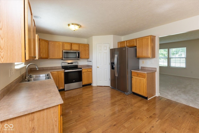 6516 Amherst Way, Zionsville, IN 46077 - kitchen featuring appliances with stainless steel finishes, light wood-style flooring, light countertops, and a textured ceiling