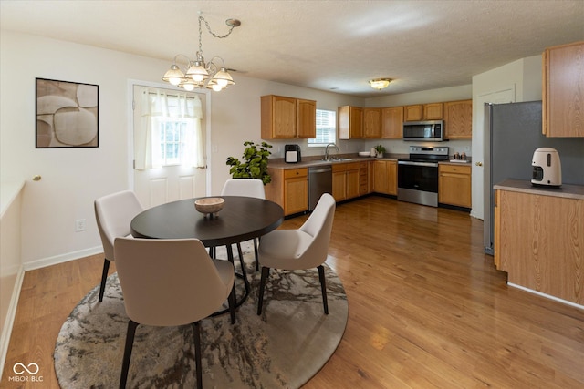 6516 Amherst Way, Zionsville, IN 46077 - dining room with wood finished floors, a chandelier, and a textured ceiling
