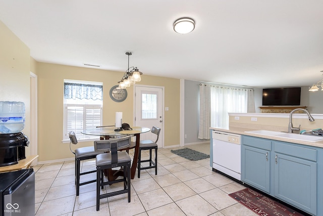 5646 Skipping Stone Dr, Indianapolis, IN 46237 - kitchen featuring white dishwasher, a sink, decorative light fixtures, and light tile patterned floors