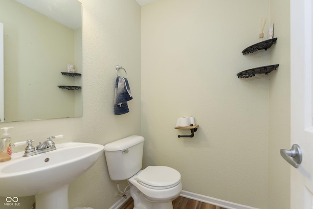 5646 Skipping Stone Dr, Indianapolis, IN 46237 - half bathroom featuring a sink, toilet, wood finished floors, and baseboards
