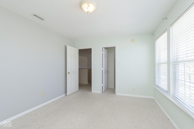 5646 Skipping Stone Dr, Indianapolis, IN 46237 - unfurnished bedroom featuring light carpet, multiple windows, and baseboards