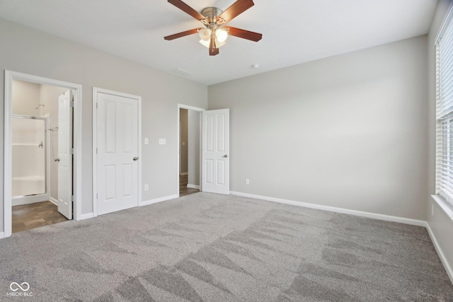 unfurnished bedroom featuring carpet flooring, baseboards, ensuite bathroom, and a ceiling fan
