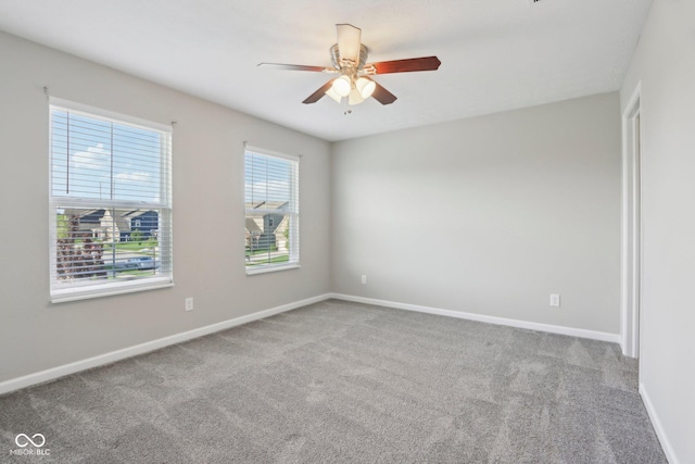 spare room featuring carpet, a ceiling fan, and baseboards