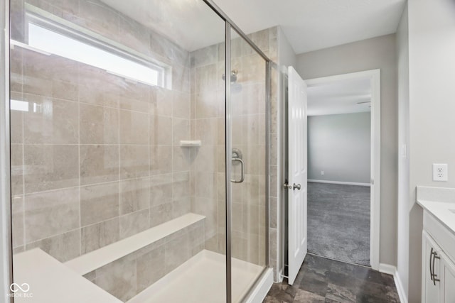 full bathroom featuring a stall shower, vanity, and baseboards