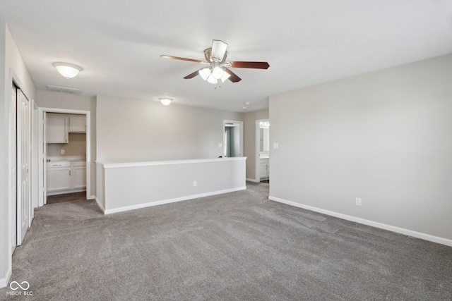 carpeted empty room featuring a ceiling fan and baseboards