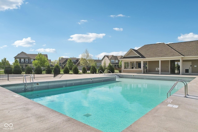 community pool with fence and a patio area