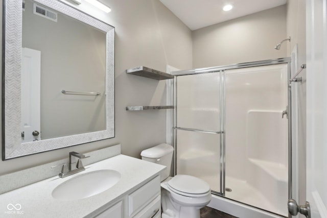 bathroom featuring a shower stall, toilet, vanity, and recessed lighting