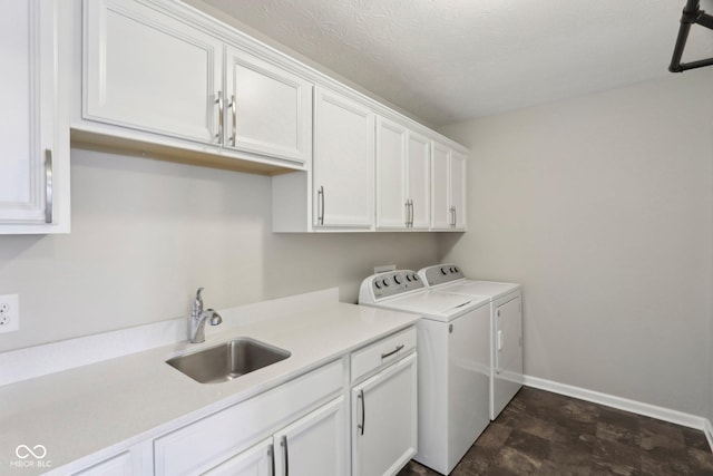 laundry room with independent washer and dryer, cabinet space, baseboards, and a textured ceiling