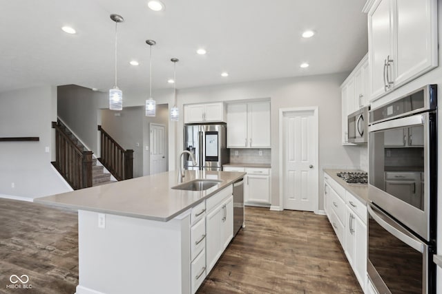 kitchen featuring stainless steel appliances, a sink, recessed lighting, dark wood-style flooring, and light countertops