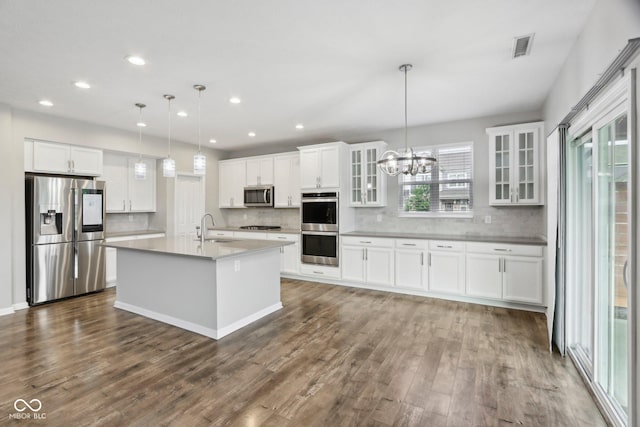 kitchen with appliances with stainless steel finishes, a sink, decorative backsplash, dark wood-style flooring, and recessed lighting