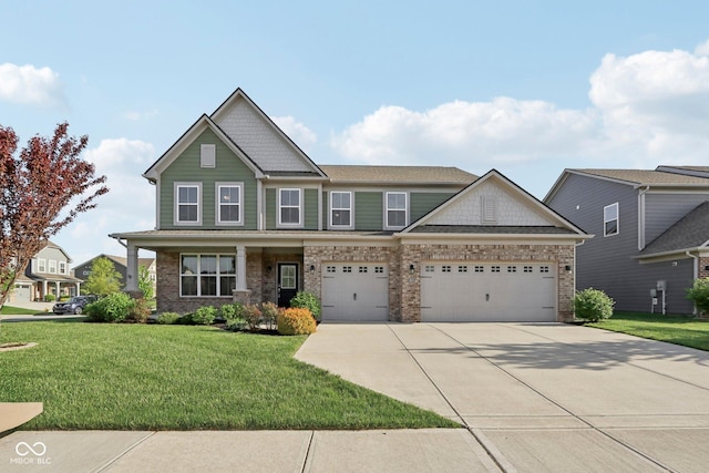 craftsman inspired home with driveway, a front yard, a garage, and brick siding