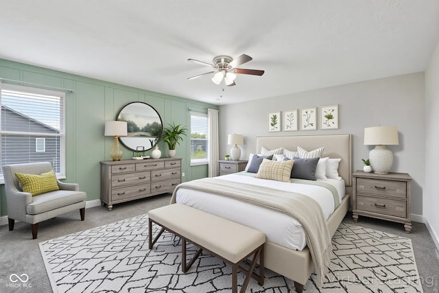 bedroom featuring light colored carpet, baseboards, and a ceiling fan