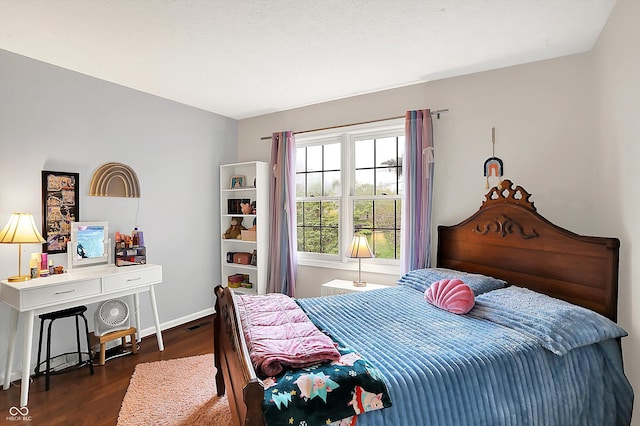 bedroom with baseboards and wood finished floors