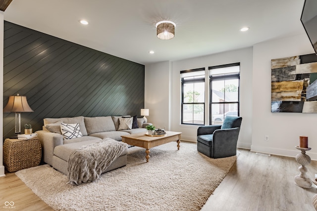 1534 Fletcher Ave, Indianapolis, IN 46203 - living area featuring an accent wall, recessed lighting, wood finished floors, and wood walls
