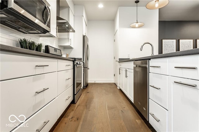622 E 10th St Unit 212, Indianapolis, IN 46202 - kitchen with white cabinetry, hardwood / wood-style floors, dark countertops, and stainless steel appliances