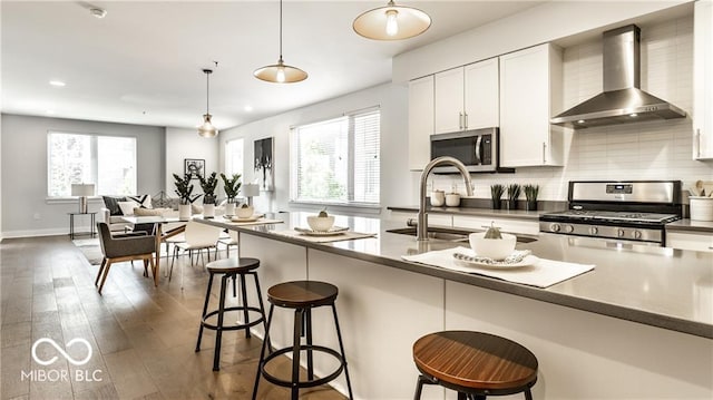 622 E 10th St Unit 212, Indianapolis, IN 46202 - kitchen with a sink, dark wood finished floors, wall chimney exhaust hood, stainless steel appliances, and decorative backsplash