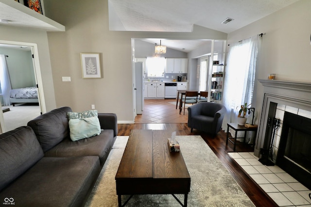 10688 Ashview Dr, Fishers, IN 46038 - living room with a fireplace with flush hearth, visible vents, light wood-style floors, and lofted ceiling