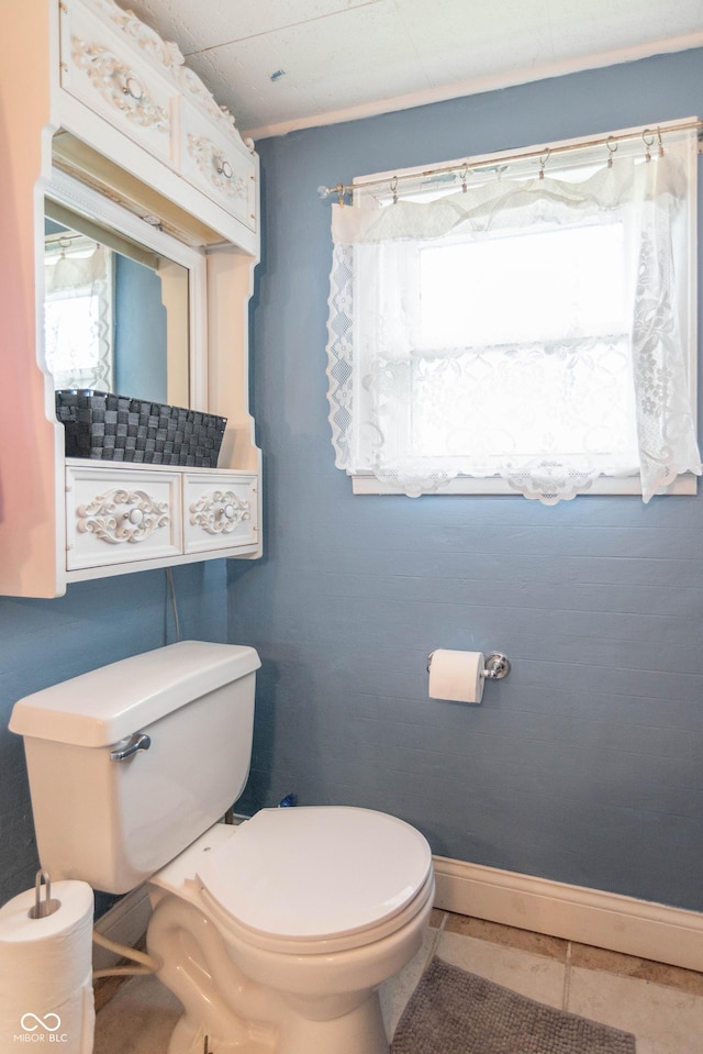 half bath with toilet and tile patterned flooring